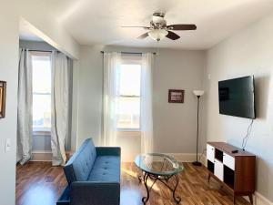 a living room with a blue couch and a ceiling fan at LG Lofts -1 bedroom unit in Kiel close to Road America Elkhart Lake in Kiel