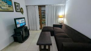 a living room with a couch and a tv at Depto Playa Grande in Mar del Plata