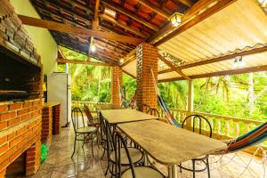 d'une terrasse avec des tables et des chaises ainsi que d'une terrasse couverte avec dans l'établissement Chácara pé n'água, 80 km de SP, piscina e spa aquecido, à São Paulo