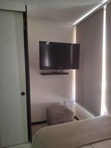 Una televisión o centro de entretenimiento en Cómodo departamento