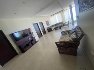 a living room with a couch and a television at Departamento al pie del mar con hermosa vista in Cautivo
