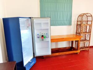 un frigorifero con la porta aperta accanto a un tavolo di Helios Beach Resort a Tangalle