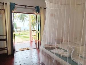 una camera da letto con un letto con vista sull'oceano di Helios Beach Resort a Tangalle