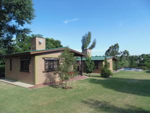 a small house with a tree in the yard at Cabañas los amigos Pino in Potrero de Garay