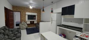 Una cocina con electrodomésticos blancos y una sala de estar. en Lar de Amilton, en Cabo Frío 31 fotos más