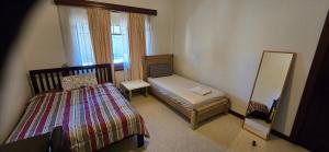 a small bedroom with a bed and a mirror at Peaceful Haven Guest House, in Adelaide