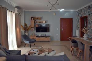 Una sala de estar con un sofá y un televisor. en Christina's Apartment, en Nauplia