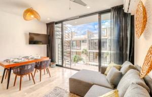 a living room with a couch and a table at Amena Condo Tulum in Tulum