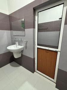 a bathroom with a toilet and a sink and a door at KBS Golden House in Point Pedro +15 photos
