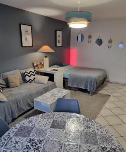 a living room with two beds and a couch at Appartement de 51 m2 avec jardin de 51 m2, parking privé in Achères