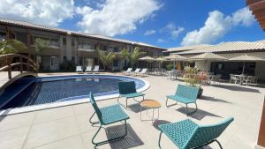 a patio with chairs and a swimming pool at Itacimirim Bioflora - Térreo 2 Suítes in Itacimirim +48 photos