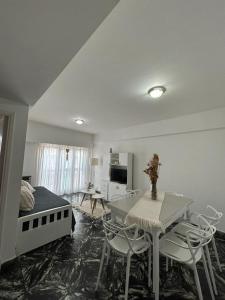 a bedroom with a bed and a table and chairs at EMBE DEPARTAMENTO Necochea in Necochea