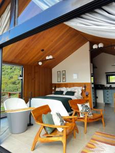 a master bedroom with a bed and a tub at Cabana Nórdica com Maravilhosa Vista da Serra in Gonçalves