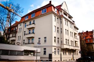 a large white building with a red roof at Apartamenty 23 in Poznań