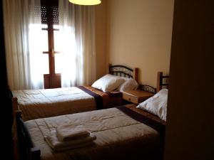 una habitación con 3 camas y una cruz en la ventana en Selgas de Cudillero en Cudillero