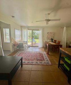 穆伦宾比Beautiful, comfortable 7 mins walk to Mullumbimby的带吊扇和桌子的客厅 更多21张照片