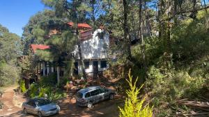 dos coches aparcados delante de una casa en Cabaña Linda vista, en Mazamitla