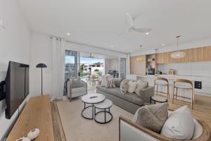 a living room with a couch and a table at Stylish 4-Bed Waterfront Home with Private Pool in Maroochydore