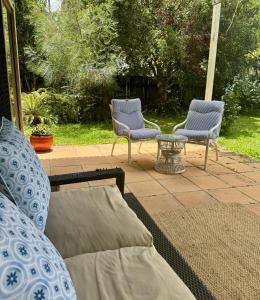 穆伦宾比Beautiful, comfortable 7 mins walk to Mullumbimby的有两把椅子和一张桌子的露台