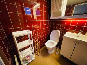 un bagno piastrellato rosso con un water e un lavandino di Trondheim City Stay a Trondheim
