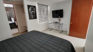 a bedroom with a bed and a tv and a table at Casa de Lucas in Balvanera