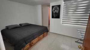 a bedroom with a bed in a white room at Casa de Lucas in Balvanera