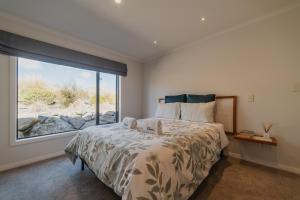 A bed or beds in a room at Cedar Sky - 3BR Near Lake Tekapo and Mt John