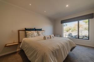 A bed or beds in a room at Cedar Sky - 3BR Near Lake Tekapo and Mt John