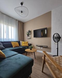 a living room with a blue couch and a table at Grandma's house in Rogoznica