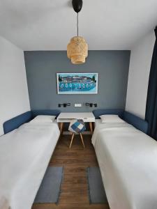 a small room with two beds and a table at Grandma's house in Rogoznica