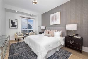 a bedroom with a large white bed and a window at Skyline Royale Penthouse - Downtown Toronto - CN Tower View, Balcony, Pool, Hot Tub in Toronto