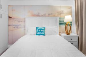 代托纳海滩Ocean Front and Pool Front At Daytona Inn Beach Resort的卧室配有白色床和蓝色枕头