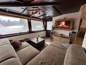 a living room with a couch and a tv at Chata Miracle in Slapy