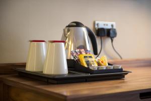 a coffee pot and two cups on a table at The Crown & Greyhound by Innkeeper's Collection in London