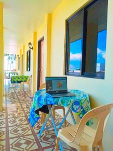 ein Laptop-Computer, der auf einem Tisch in einem Raum steht in der Unterkunft Stockton Inn Siquijor in San Juan