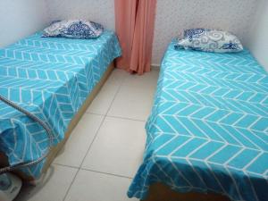 two beds sitting next to each other in a room at Apto Caldas Novas in João Pessoa