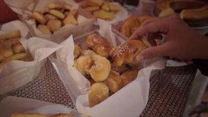 a person is reaching for a box of donuts at Pousada Centaurus in Alto Paraíso de Goiás