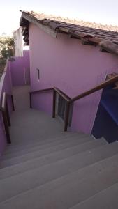 a purple building with stairs in front of it at Pousada Centaurus in Alto Paraíso de Goiás