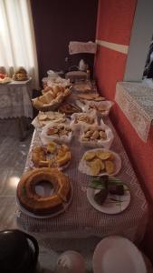 a long table with plates of food on it at Pousada Centaurus in Alto Paraíso de Goiás