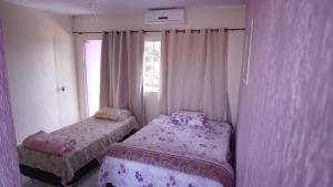 a small bedroom with two beds and a window at Pousada Centaurus in Alto Paraíso de Goiás