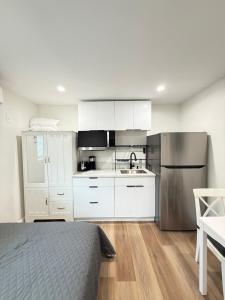 a kitchen with white cabinets and a stainless steel refrigerator at Modern Studio Stylish &Cozy Ieft Unit in Los Angeles