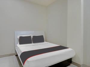 a white bed with black and white sheets in a room at Collection O Brahma Residency in Chinchiwad +18 photos