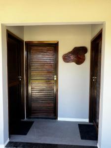 un couloir avec deux portes et un mur avec un morceau de bois dans l'établissement Fazenda Raiz da Serra, à Itaguaí 6 autres photos