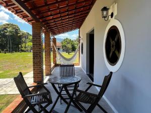 a patio with two chairs and a table at Fazenda Raiz da Serra in Itaguaí