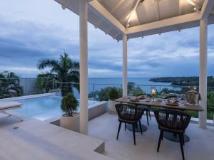 an outdoor patio with a table and chairs and a pool at Surin Seaview Villa by Elite Havens in Surin Beach