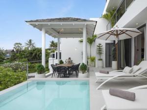an outdoor patio with a pool and a table and chairs at Surin Seaview Villa by Elite Havens in Surin Beach