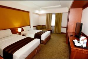 Voodi või voodid majutusasutuse Abadi Suite Hotel & Tower toas