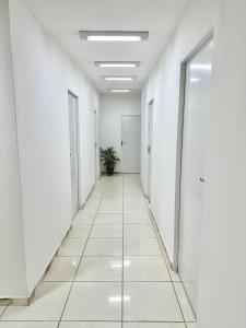 an empty corridor of an office building with white walls and white floors at Pousada Canaã in Recife