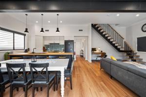 a kitchen and living room with a table and chairs at Newcastle Escape 4-Bedroom House in Hamilton