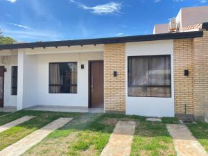 a brick house with a door and a yard at Palina Village Casa 12 - San Bernardino in San Bernardino